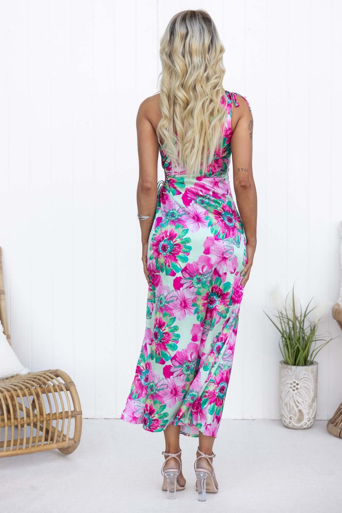 Model wearing Ronan Maxi Dress featuring vibrant floral print and one-shoulder design, shown from the back.