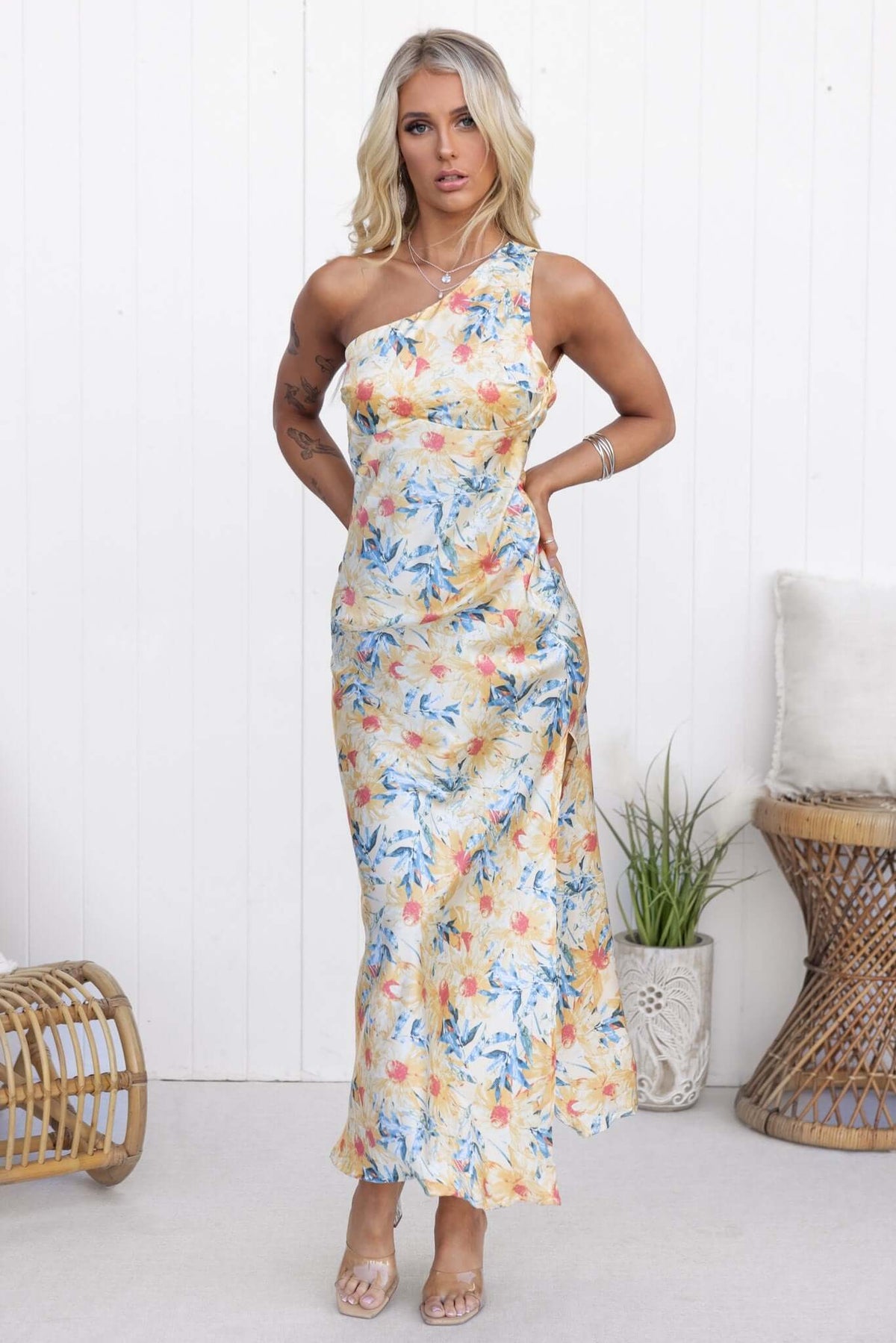 Model wearing a floral Waldena maxi dress with a one-shoulder neckline and split front, set against a white backdrop.