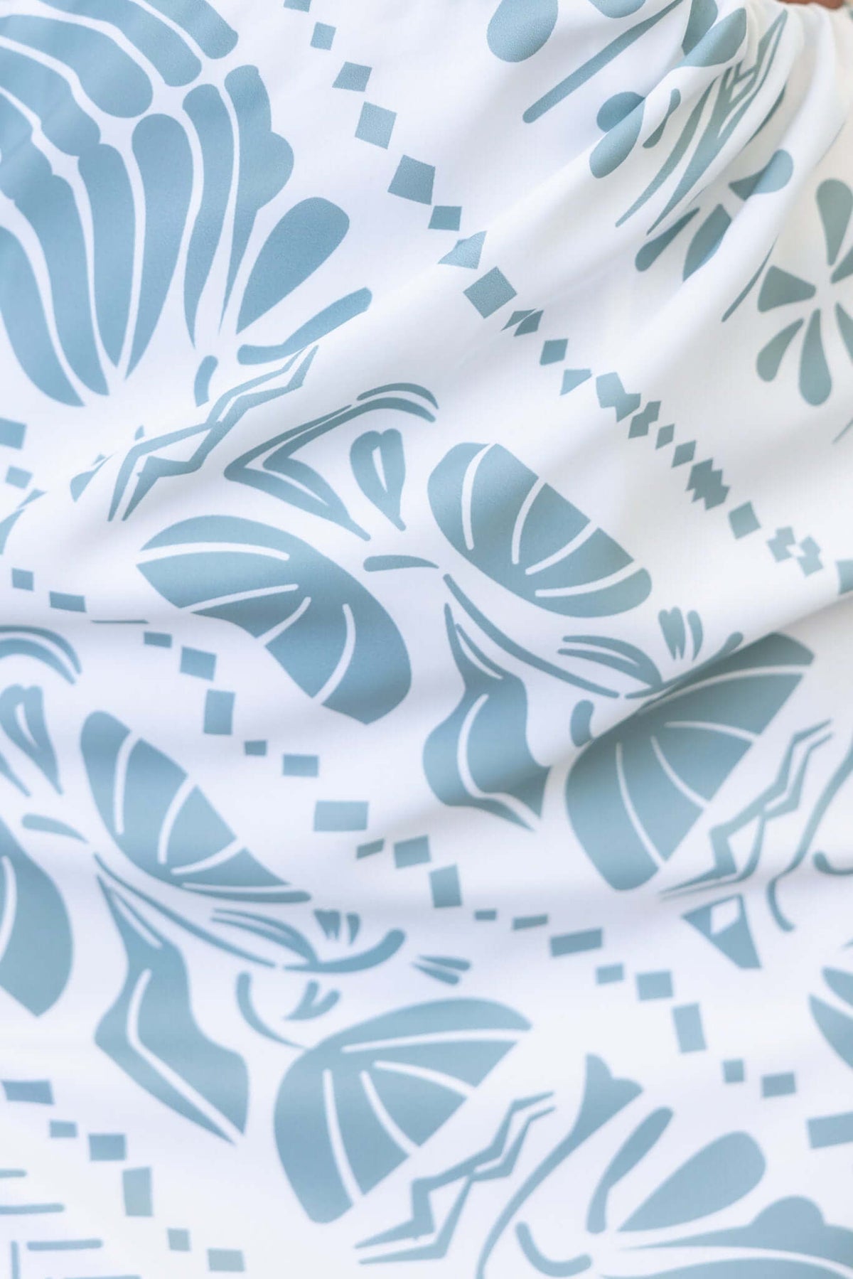 Close-up of abstract print fabric featuring floral and geometric designs in blue and white.