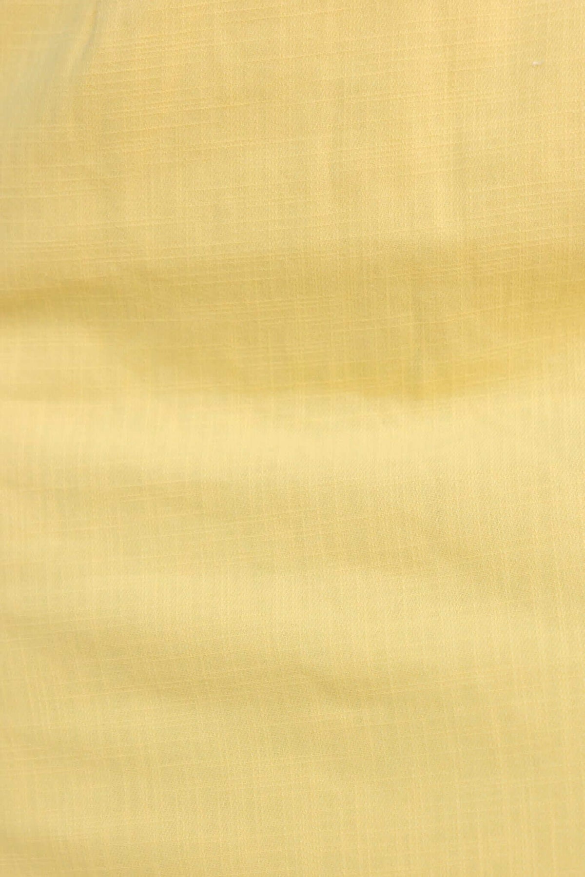 Close-up of soft yellow cotton fabric, showcasing its smooth texture and light-weight feel for apparel.