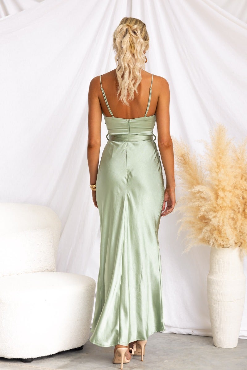 Back view of Marvellous Maxi Dress in soft green satin, featuring adjustable straps and tie detail at the waist.