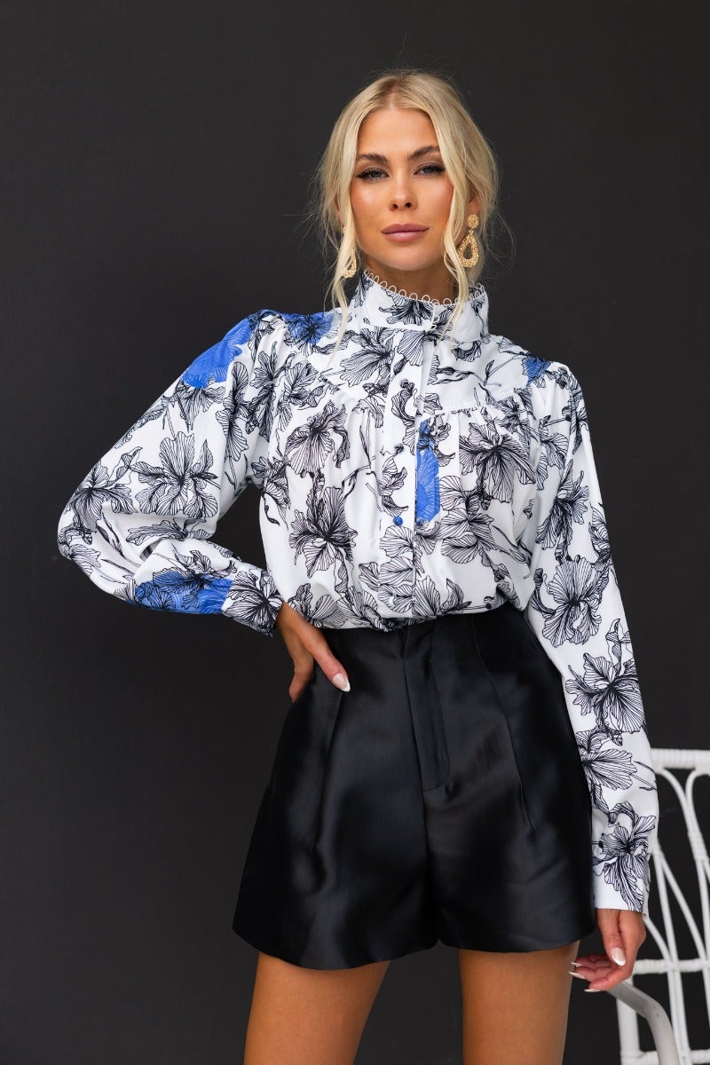 Anaya shirt featuring a floral print, high neckline, and button-up front styled with black shorts.