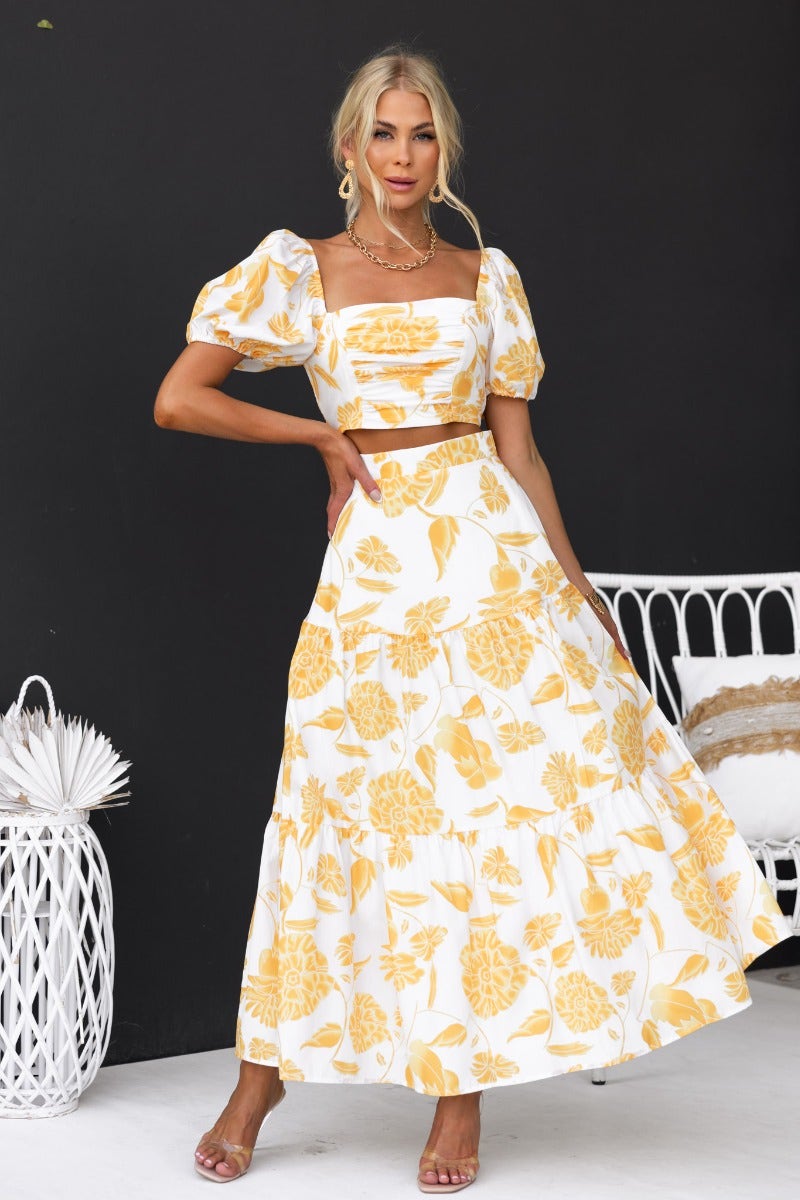 Floral print maxi set featuring puff sleeves and a back zip, styled by model in a chic outdoor setting.