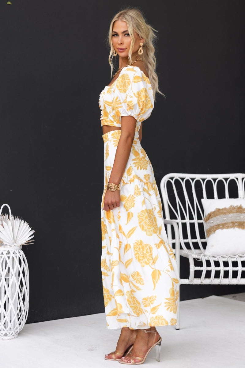 Model showcasing the Somebody To Love floral print set, featuring a maxi skirt and elastic sleeve top against a chic backdrop.