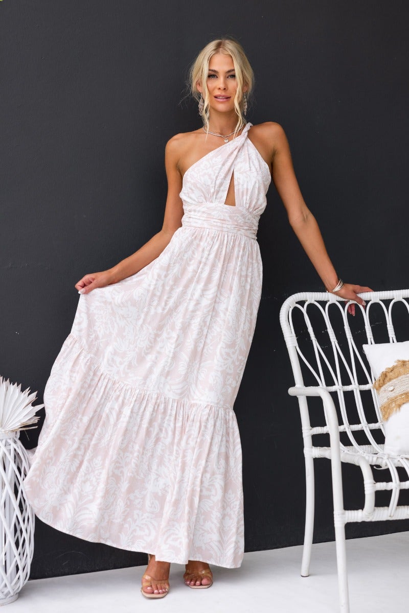 Floral print Oakland maxi dress with one-shoulder neckline and cut-out detailing, modeled against a dark background.