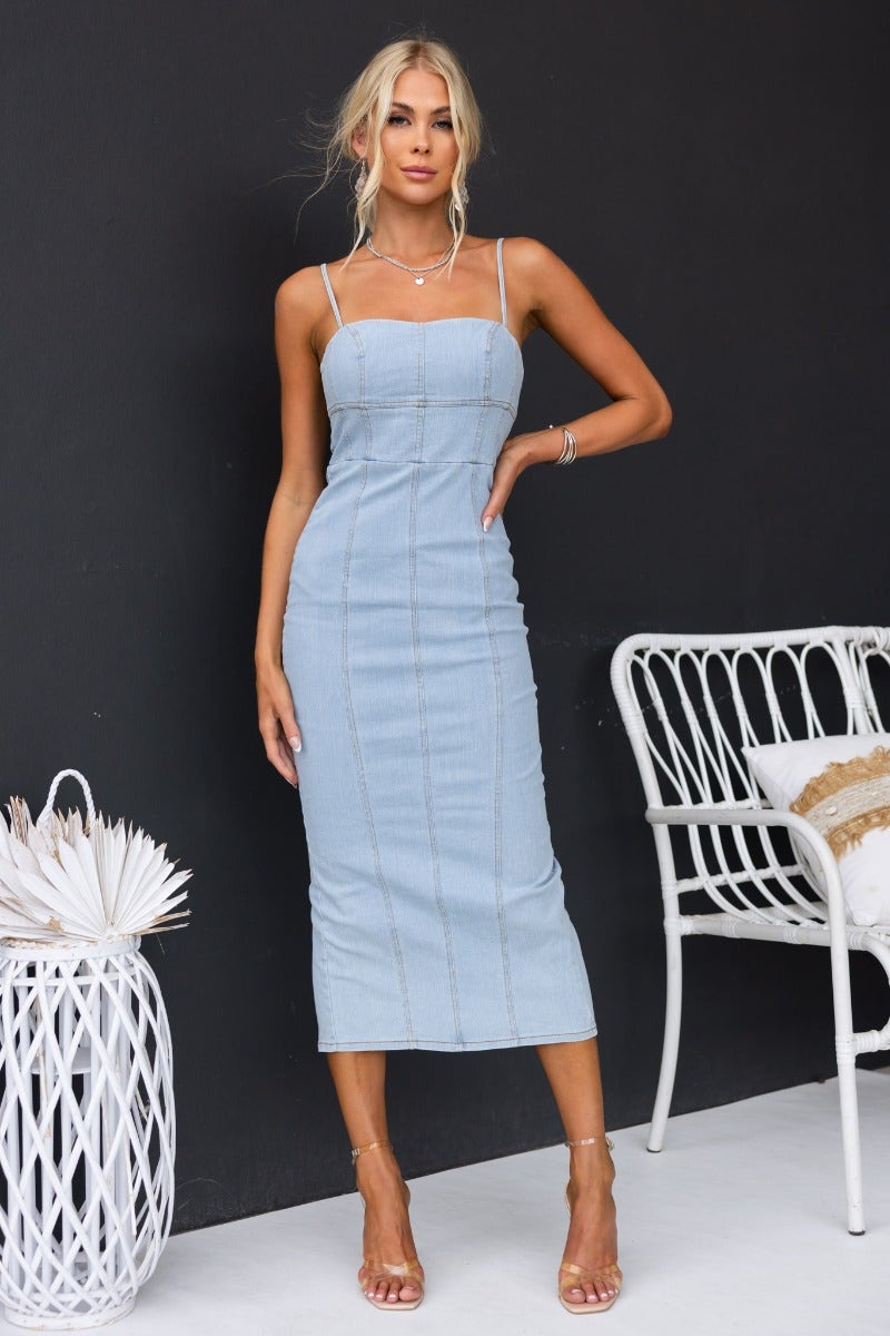 Lawsie denim midi dress with adjustable straps, zip back, and split, featuring a light denim wash and body-hugging fit.