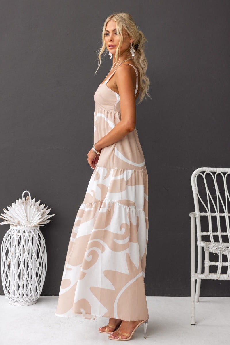 Franco Maxi Dress featuring adjustable straps, square neckline, and elegant beige floral design, model displayed in side profile.