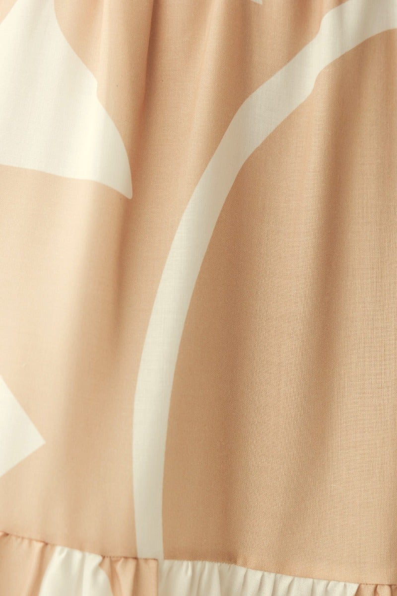 Close-up of Franco Maxi Dress fabric featuring soft peach color and white abstract print design.