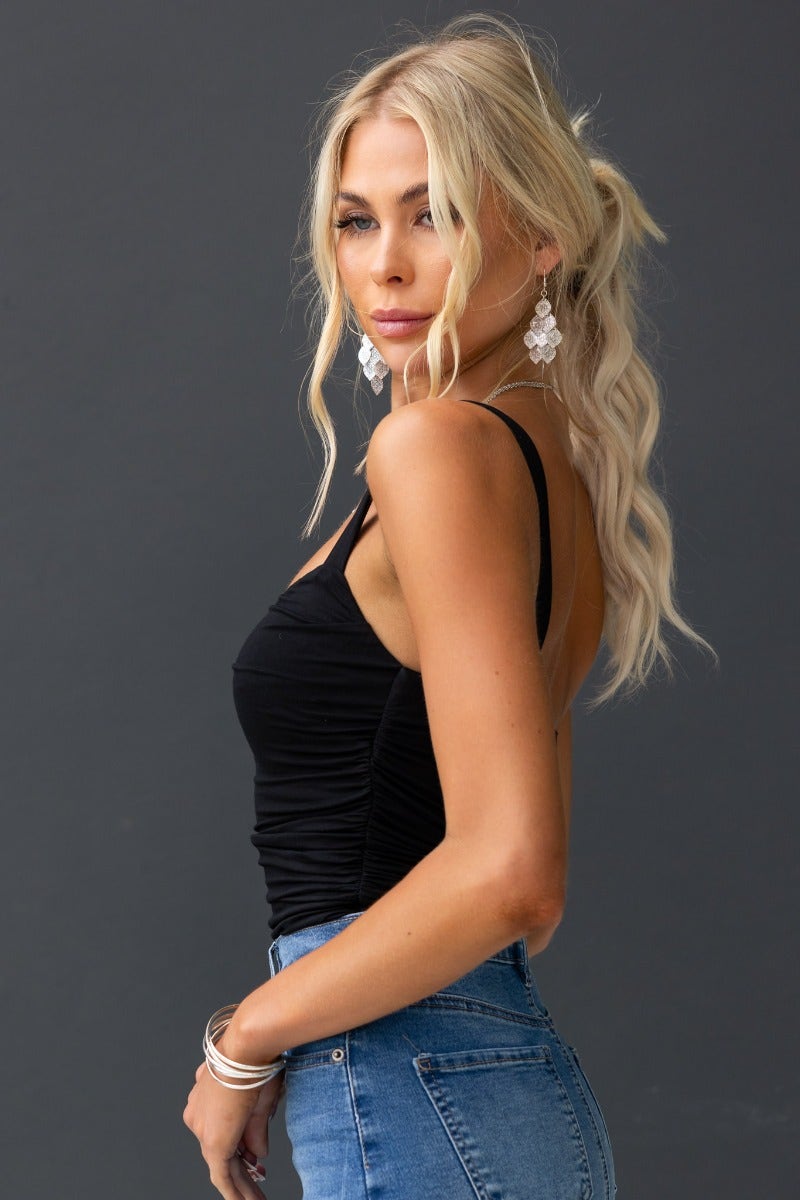 Model wearing Kodey Top, a black cotton blend top with ruching and a standard fit, paired with jeans.