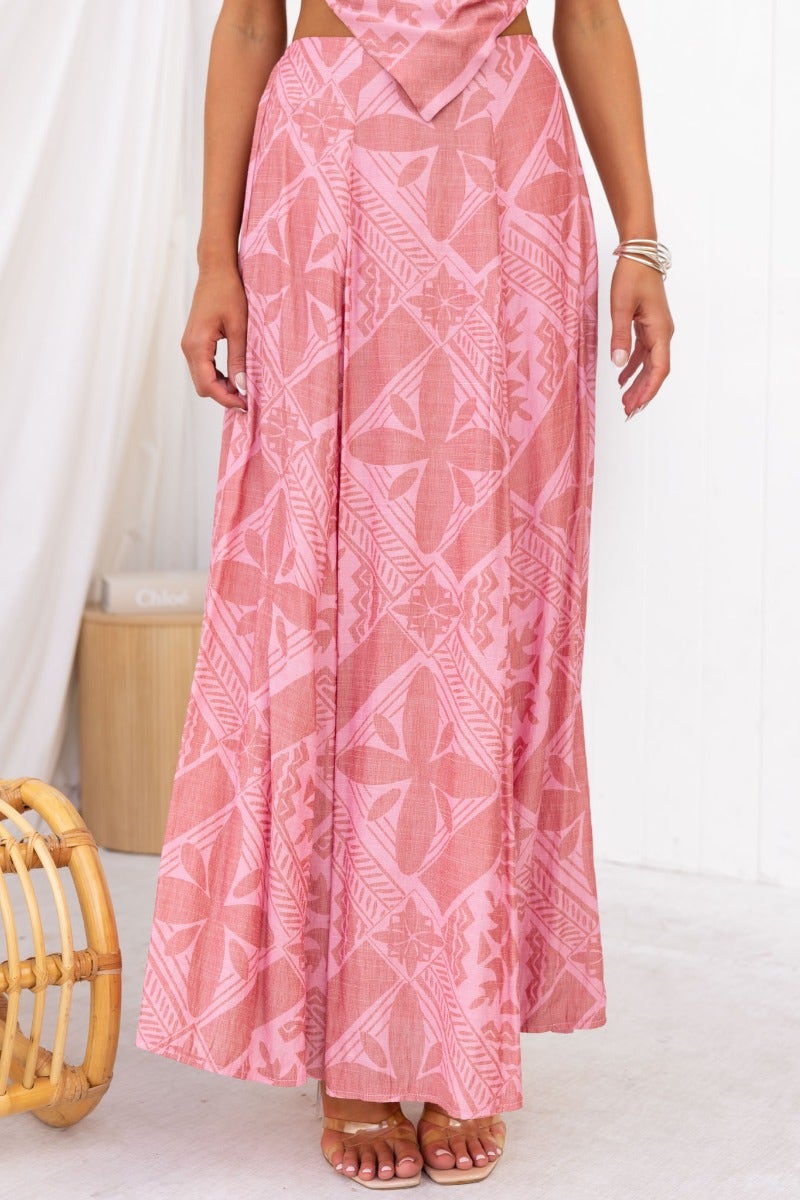 Kona Maxi Skirt in pink with geometric patterns, featuring a mid-high waist and flowy design, perfect for casual outings.