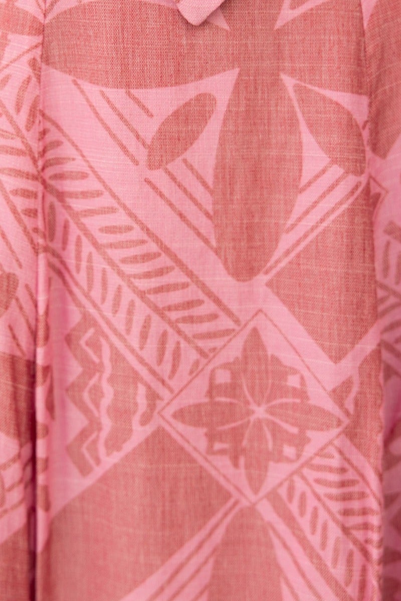 Close-up of a pink patterned fabric with floral and geometric designs, perfect for summer styles.