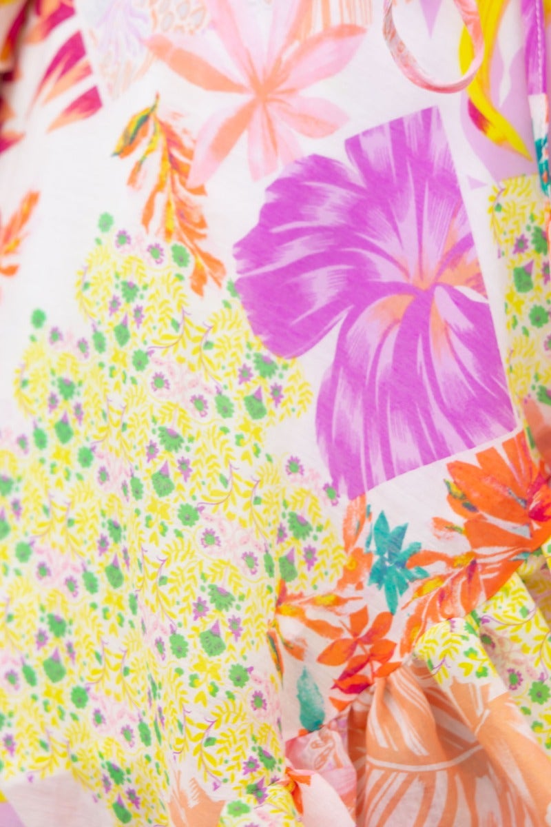 Close-up of the colorful floral pattern on the Fools Gold Wrap Dress, featuring vibrant pinks, yellows, and greens.
