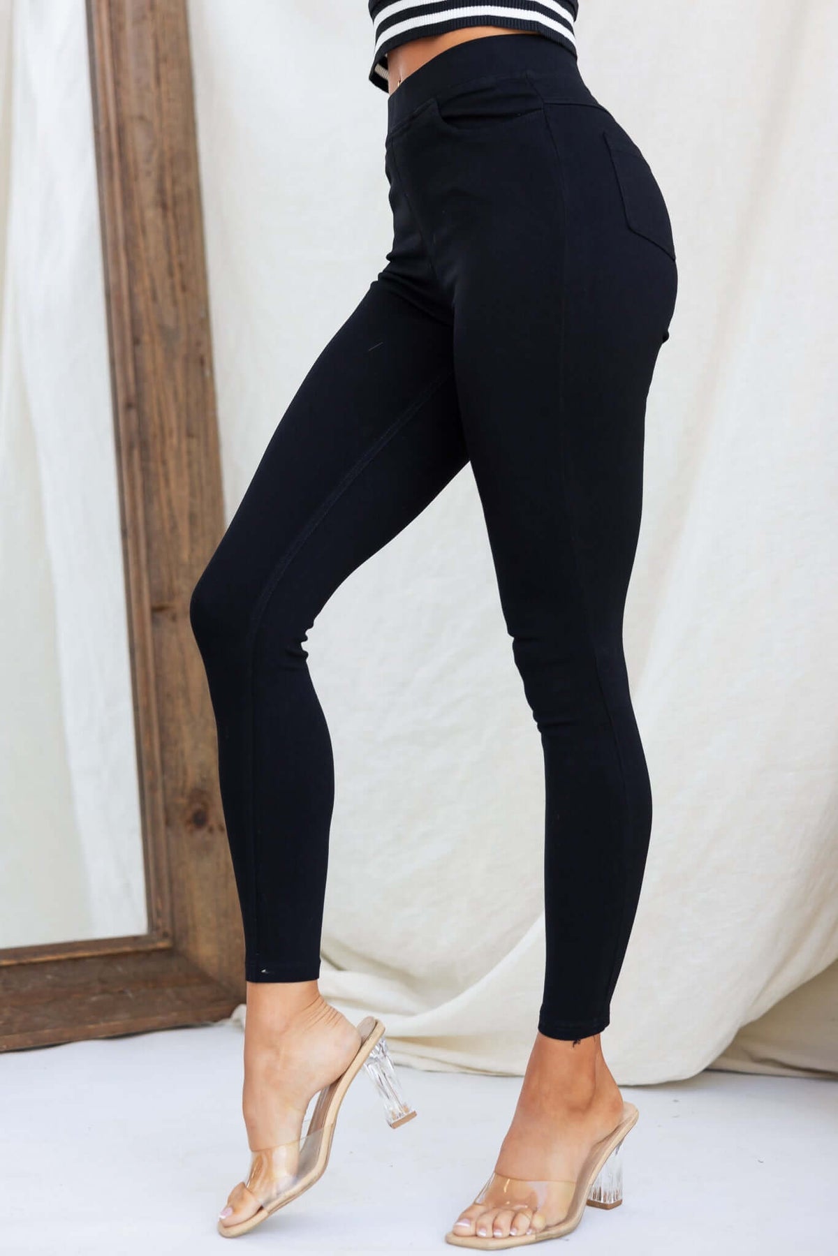 Ivan Pants in black, jeggings style with mid-high waist, elastic waistband, and pocket detail, modeled by a woman.