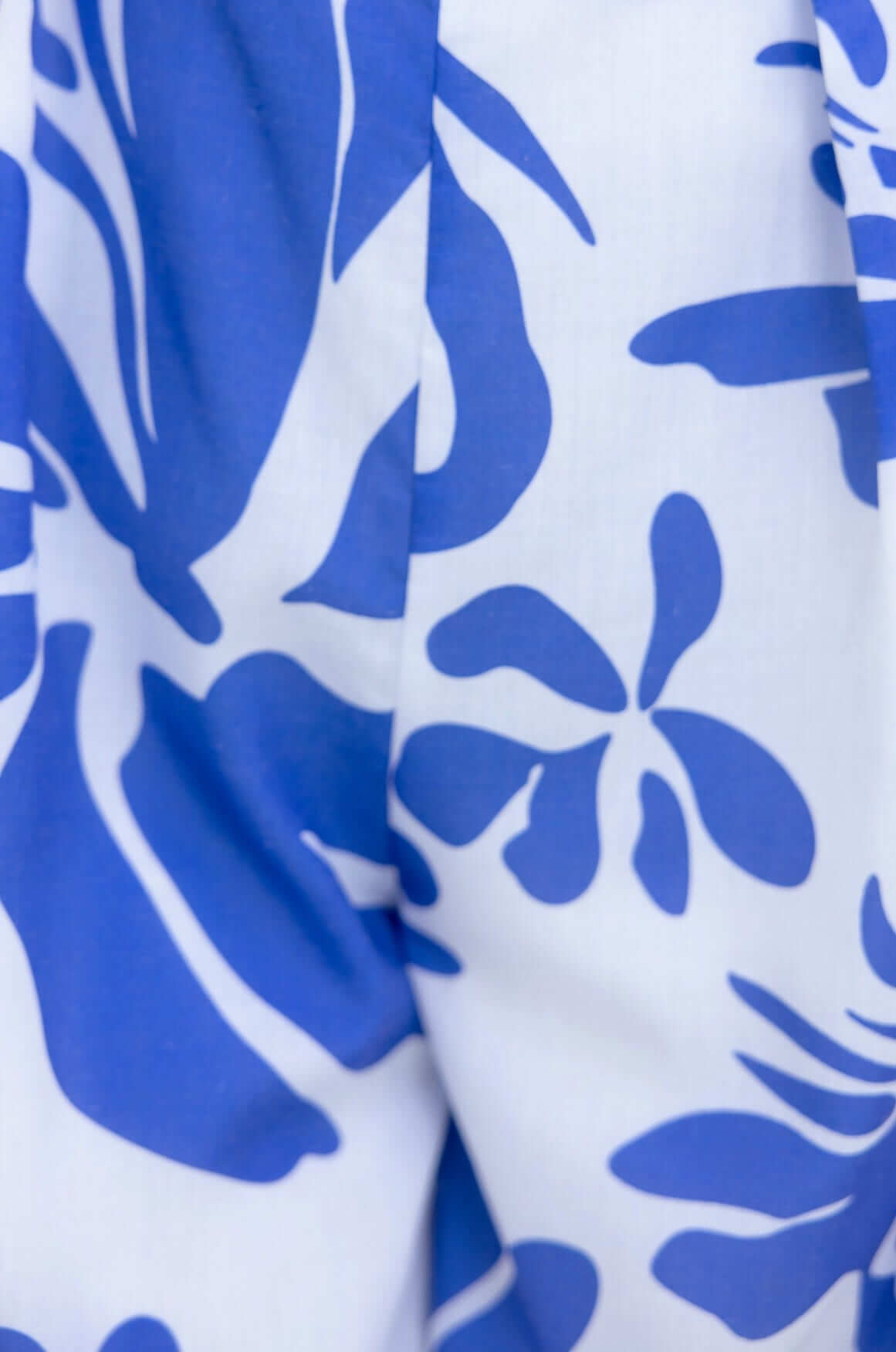 Close-up of blue floral pattern on fabric of Ivy Jumpsuit, featuring bold, tropical-inspired designs.
