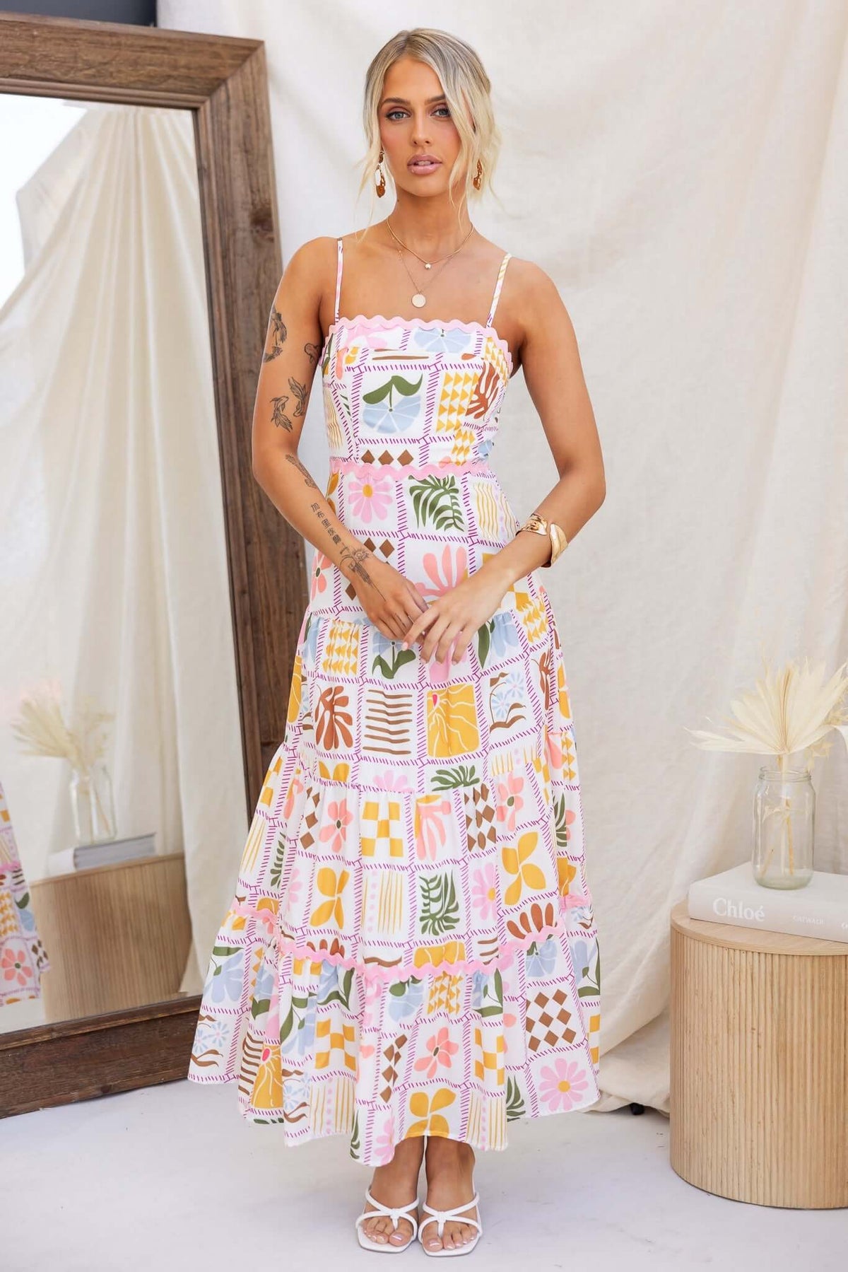 Model wearing Miffy Maxi Dress featuring colorful floral patterns, adjustable straps, and flared skirt.