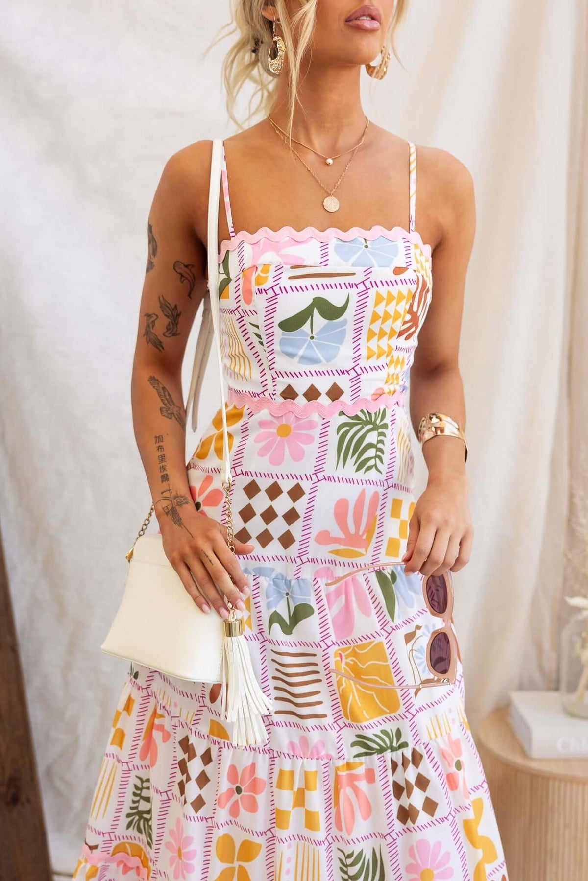 Miffy Maxi Dress worn by a model, featuring vibrant floral patterns and adjustable straps, perfect for summer outings.