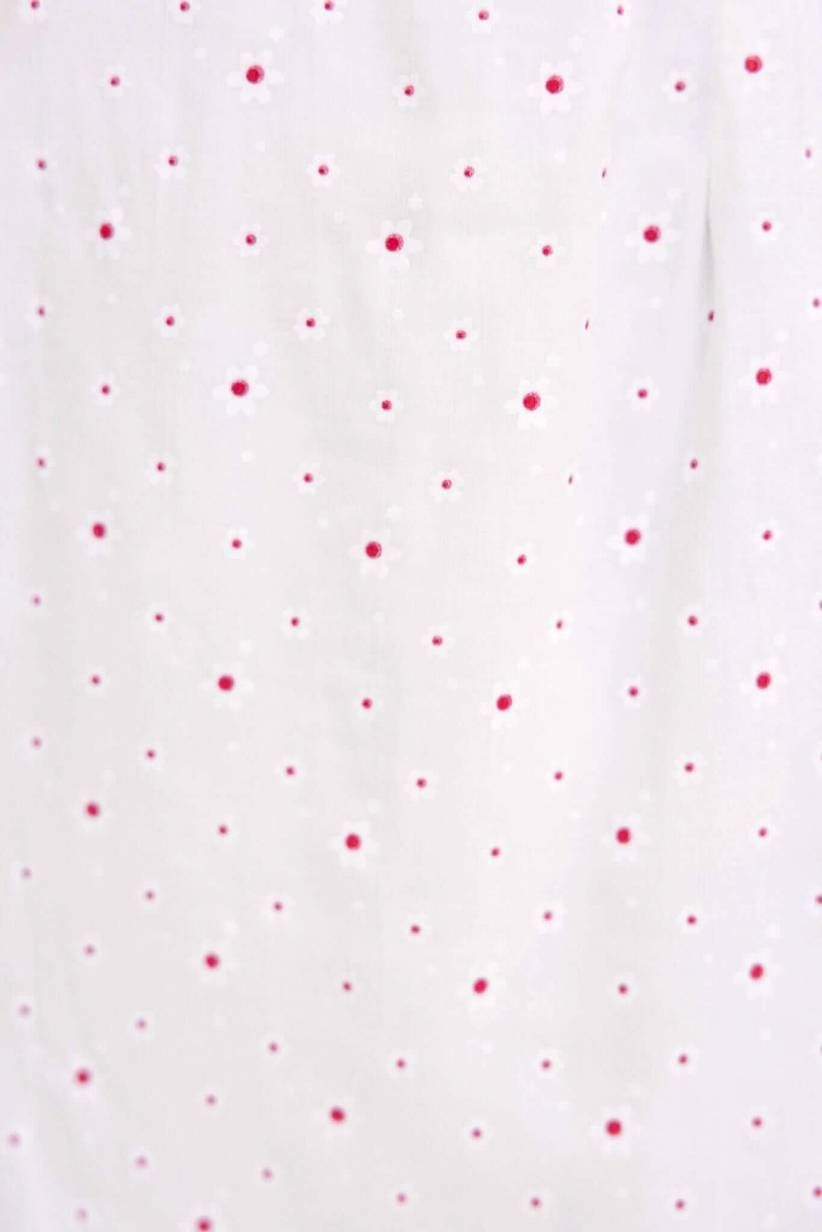 Close-up of Rouse Dress fabric featuring white background with scattered red polka dots, perfect for a playful summer look.