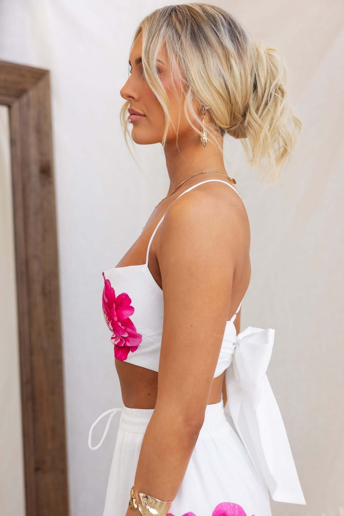 Model wearing Faly Top with adjustable straps and floral design, showcasing lightweight cotton fabric and tied back.
