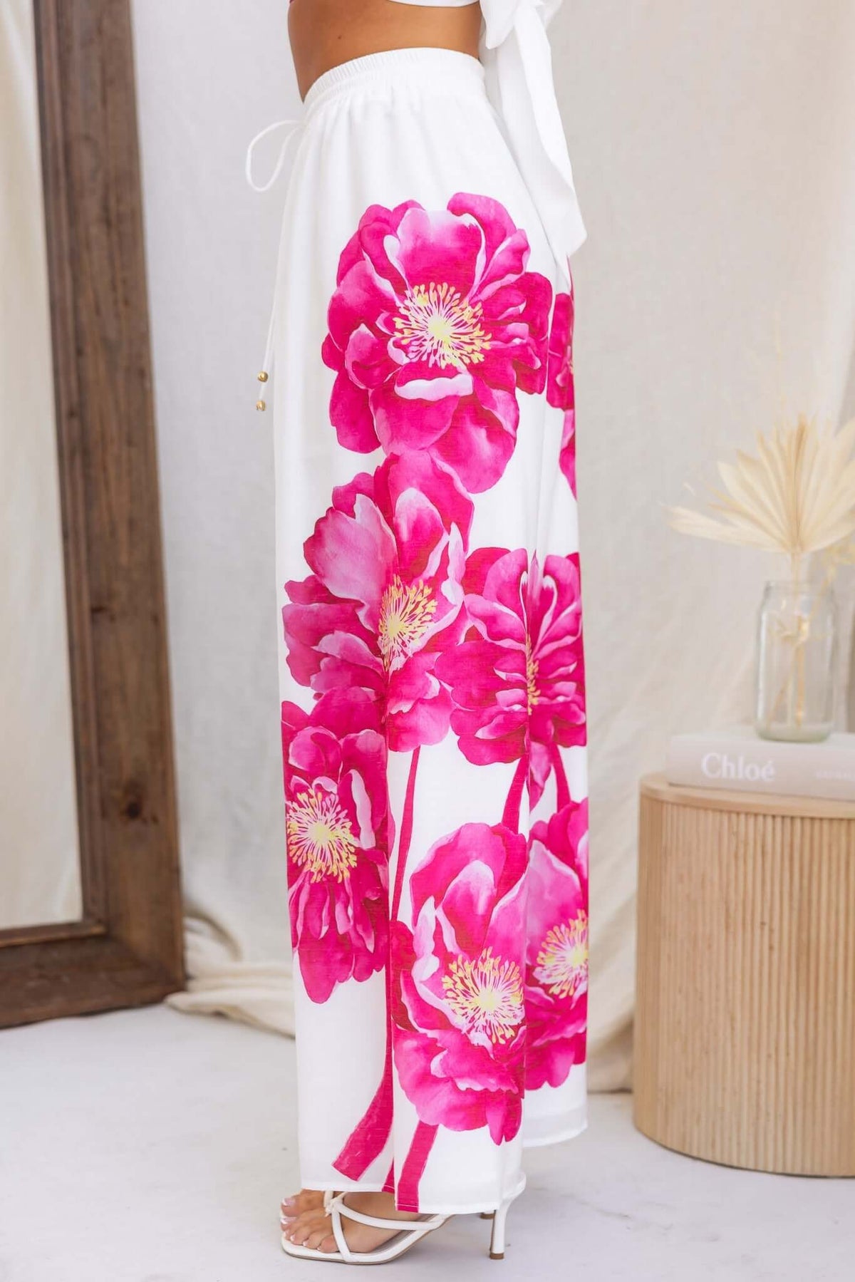 Faly Pants featuring vibrant pink floral design on lightweight cotton fabric, showcasing a mid-high waist and elastic waistband.