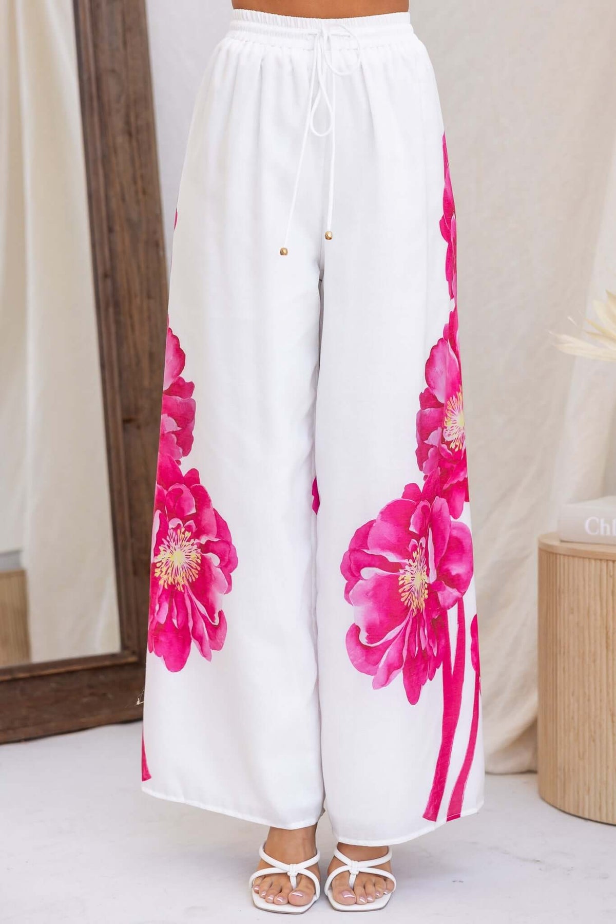 Faly Pants featuring a mid-high waist fit, elastic waistband, and bright floral print design in lightweight cotton.