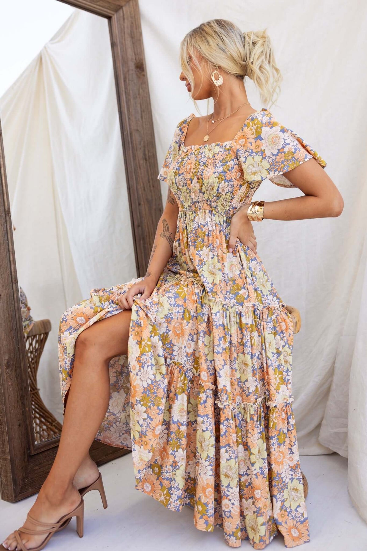 Model wearing a floral Nostalgic Maxi Dress with an elastic bodice, showcasing its stylish design and pockets.