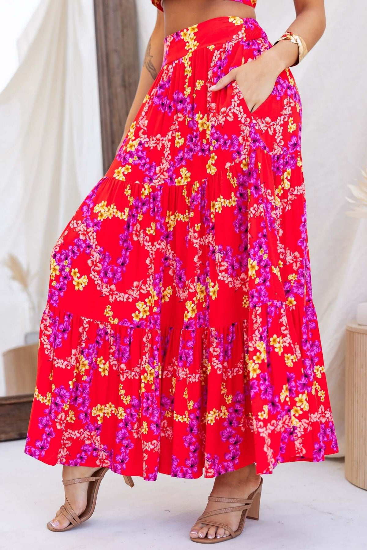 Hadid maxi skirt in vibrant red with floral print, featuring pockets, mid-high waist, and a flowing design.