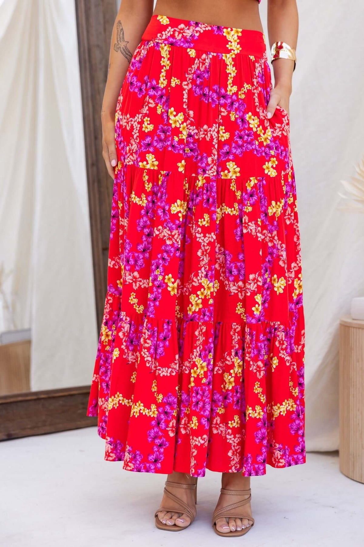 Vibrant red maxi skirt with floral print, mid-high waist fit, pockets, and elastic back for comfort and style.