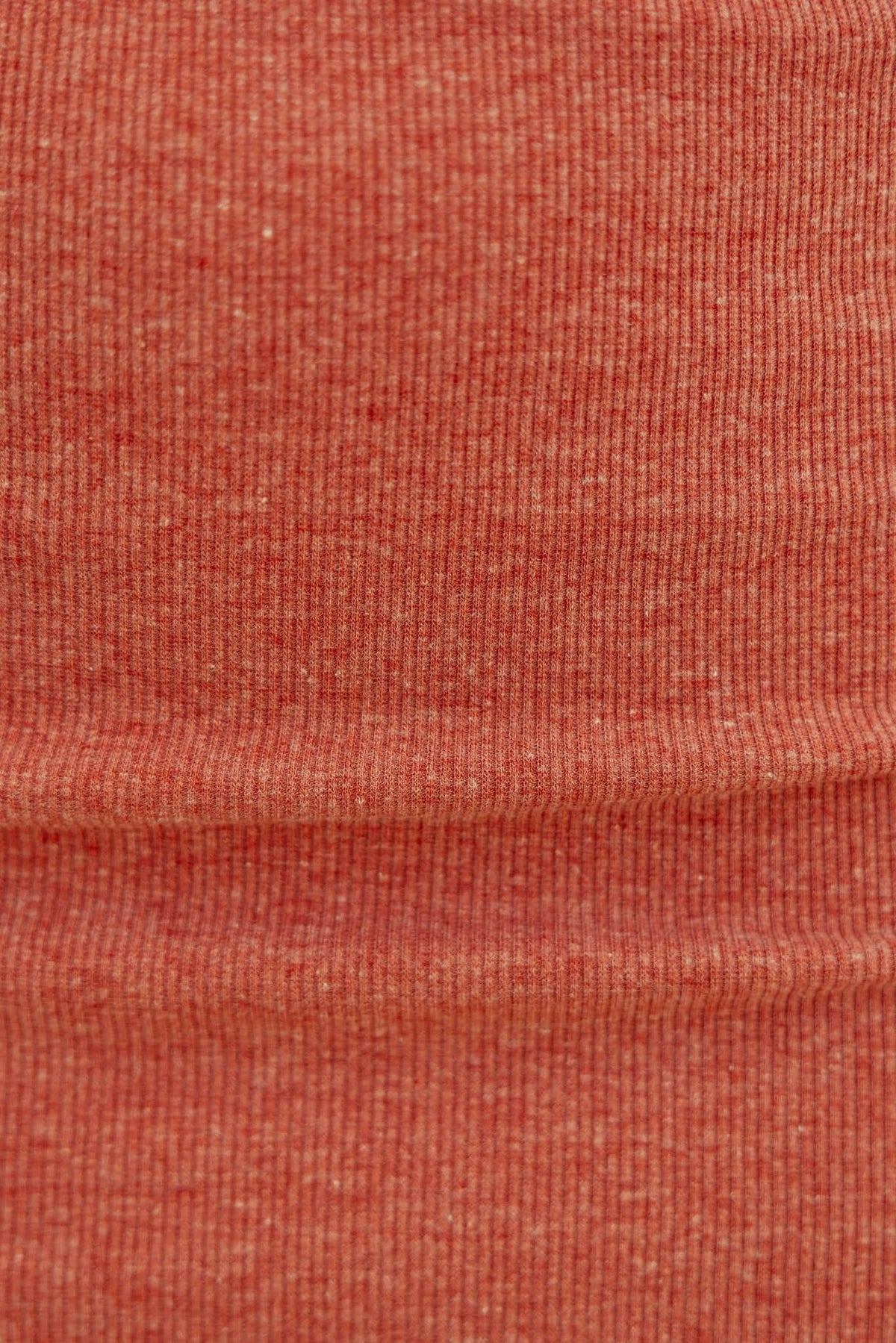 Close-up of ribbed fabric in warm coral color, ideal for comfortable, stylish tops like the Orzo Top.