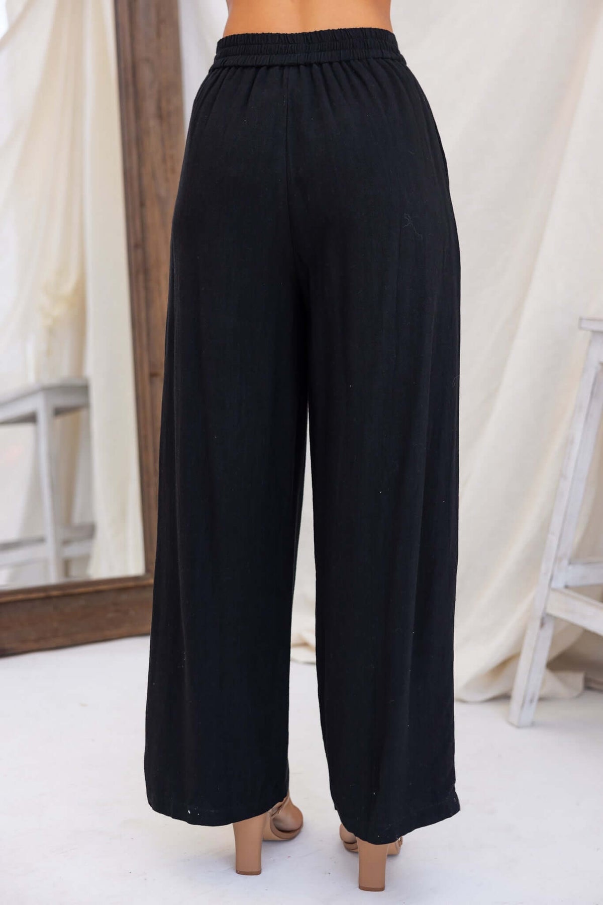 Back view of Bexley Pants, black linen wide-leg trousers with mid-high waist and elastic waistband.