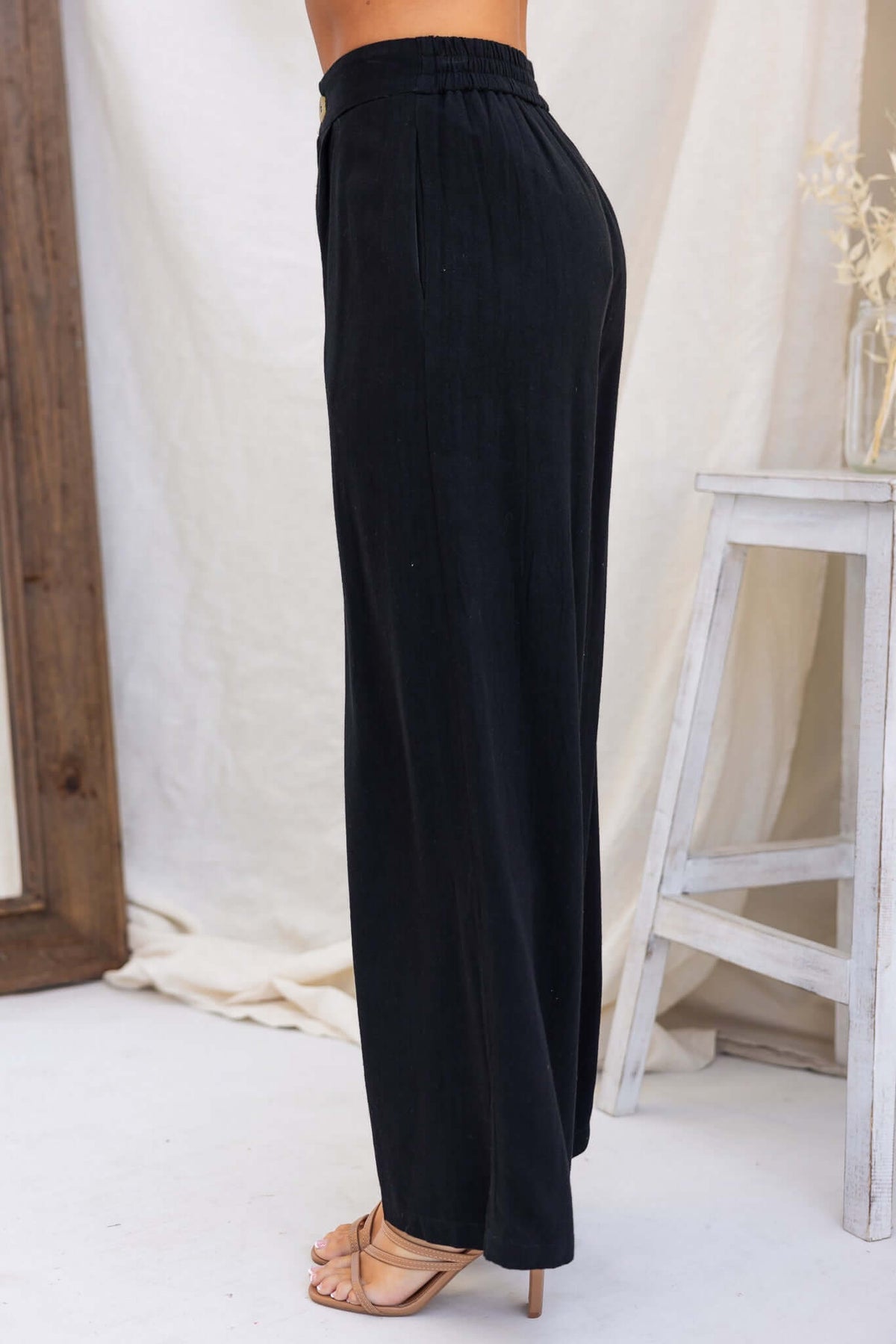 Side view of Bexley Pants, black mid-high waist with elastic waistband and pockets, showcasing a linen look.