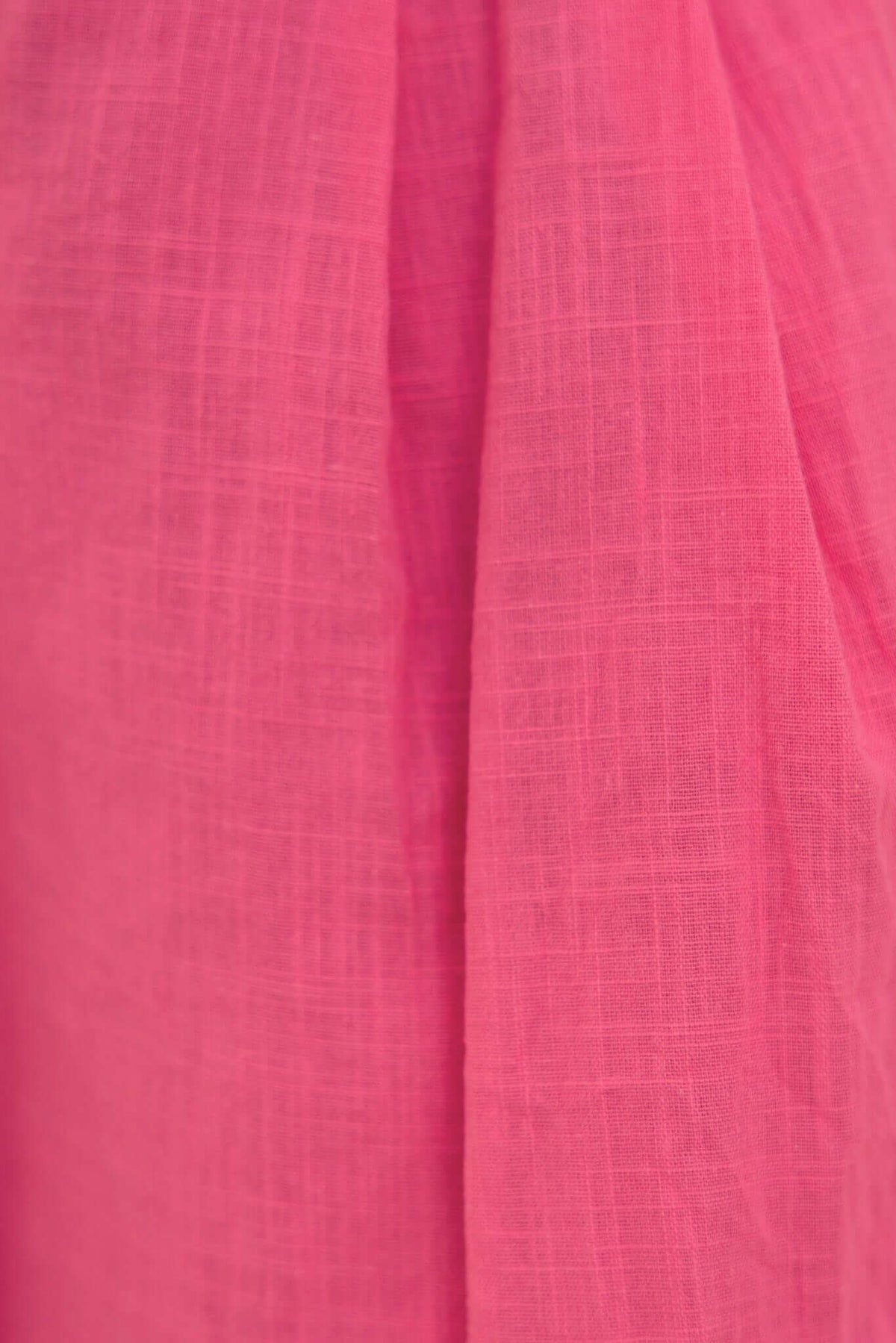 Close-up of soft pink fabric with a textured finish, showcasing the lightweight material perfect for summer wear.