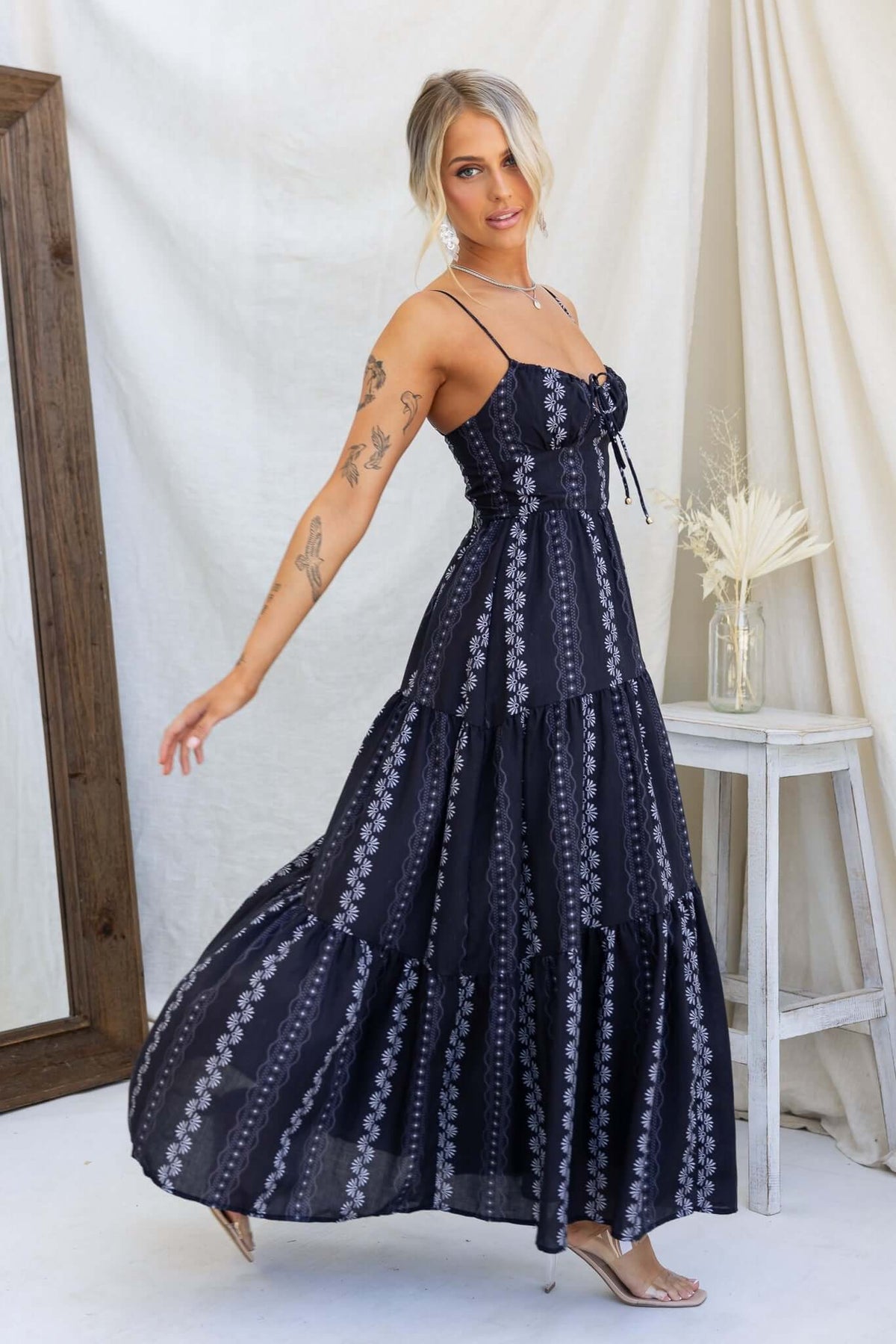 Stylish black Eider Maxi Dress with adjustable straps, tiered design, and a flowy silhouette, perfect for any occasion.