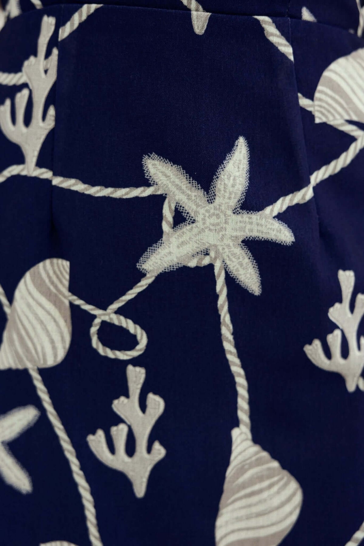 Close-up of navy fabric with white floral and coral pattern, showcasing details on the Safran Maxi Dress.