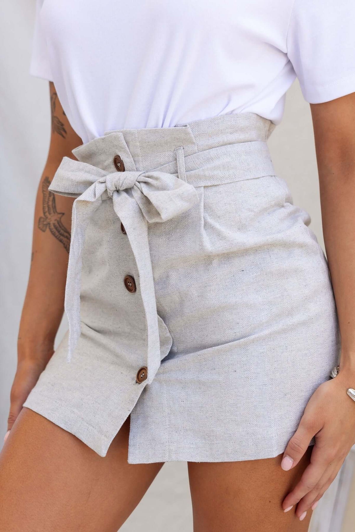 Hudson Skirt featuring a button-up front, removable belt, and tailored fit in light gray cotton fabric.