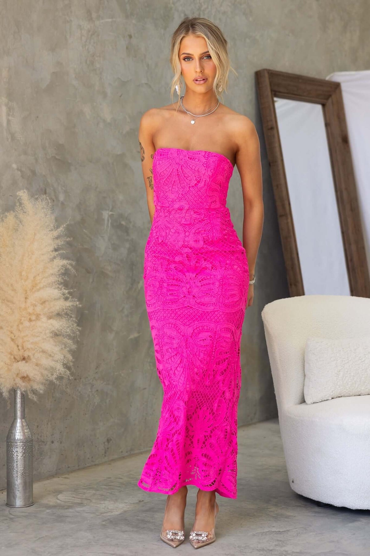 Strapless Juana Maxi Dress in vibrant pink lace, featuring an anti-slip bust and back split, styled with elegant accessories.