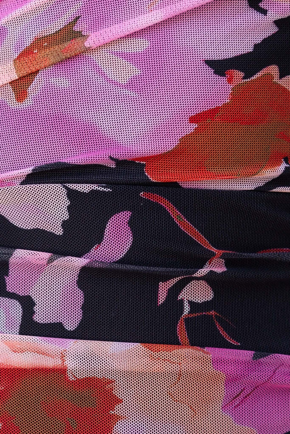 Close-up of floral mesh overlay fabric in pink, purple, and black, showcasing intricate details for a stylish maxi dress.