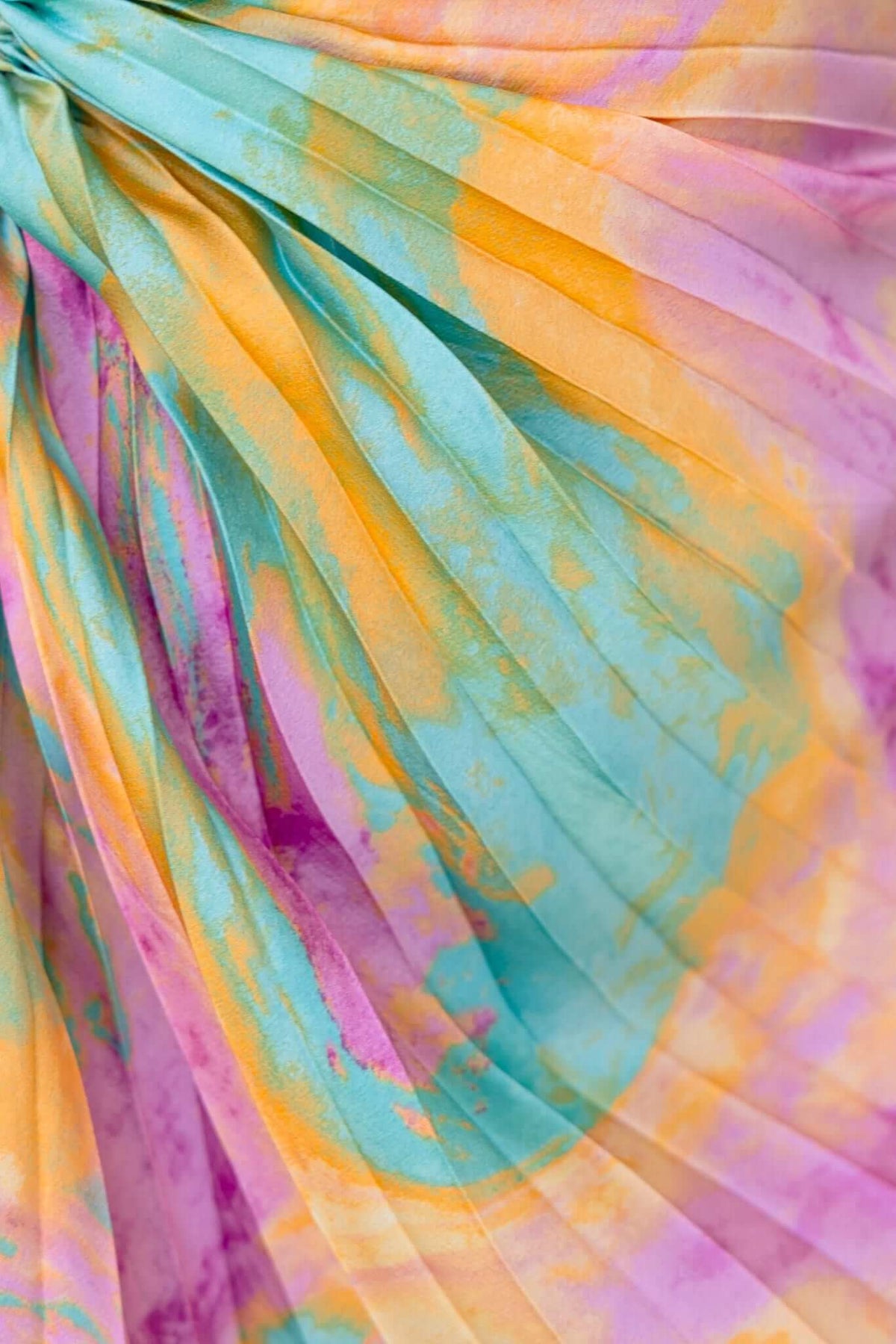 Close-up of accordion pleat fabric in vibrant orange, pink, and turquoise colors, showcasing stylish texture and design.