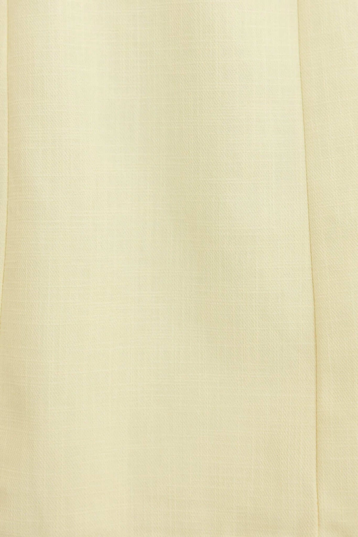 Close-up of soft beige fabric, featuring a smooth texture, ideal for stylish garments and dresses.