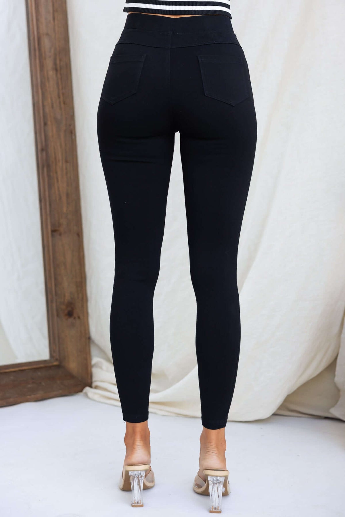 Back view of Ivan Pants, black jeggings with elastic waistband and pockets, showcasing stylish mid-high waist fit.