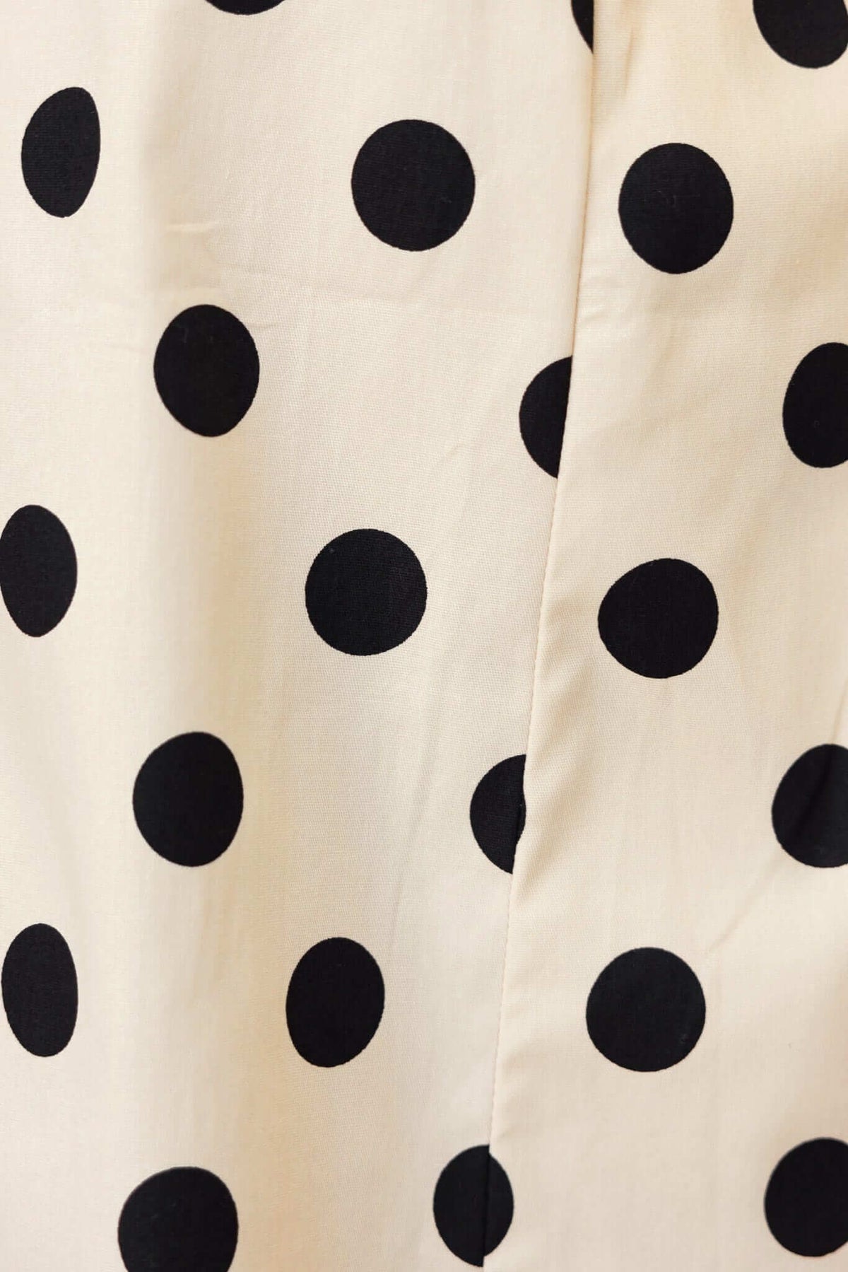 Close-up of Isibel Dress fabric featuring a cream background with large black polka dots design.