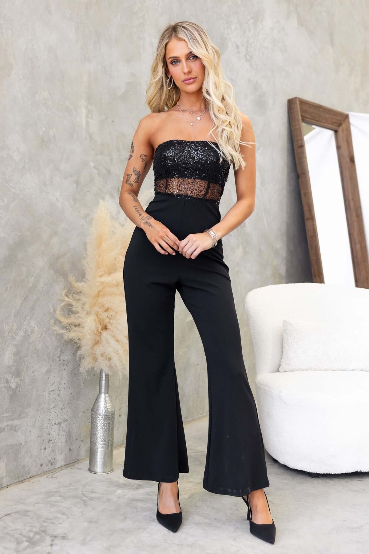 Stylish black Azura jumpsuit, strapless with sequins at bust and flared legs, perfect for evening events.