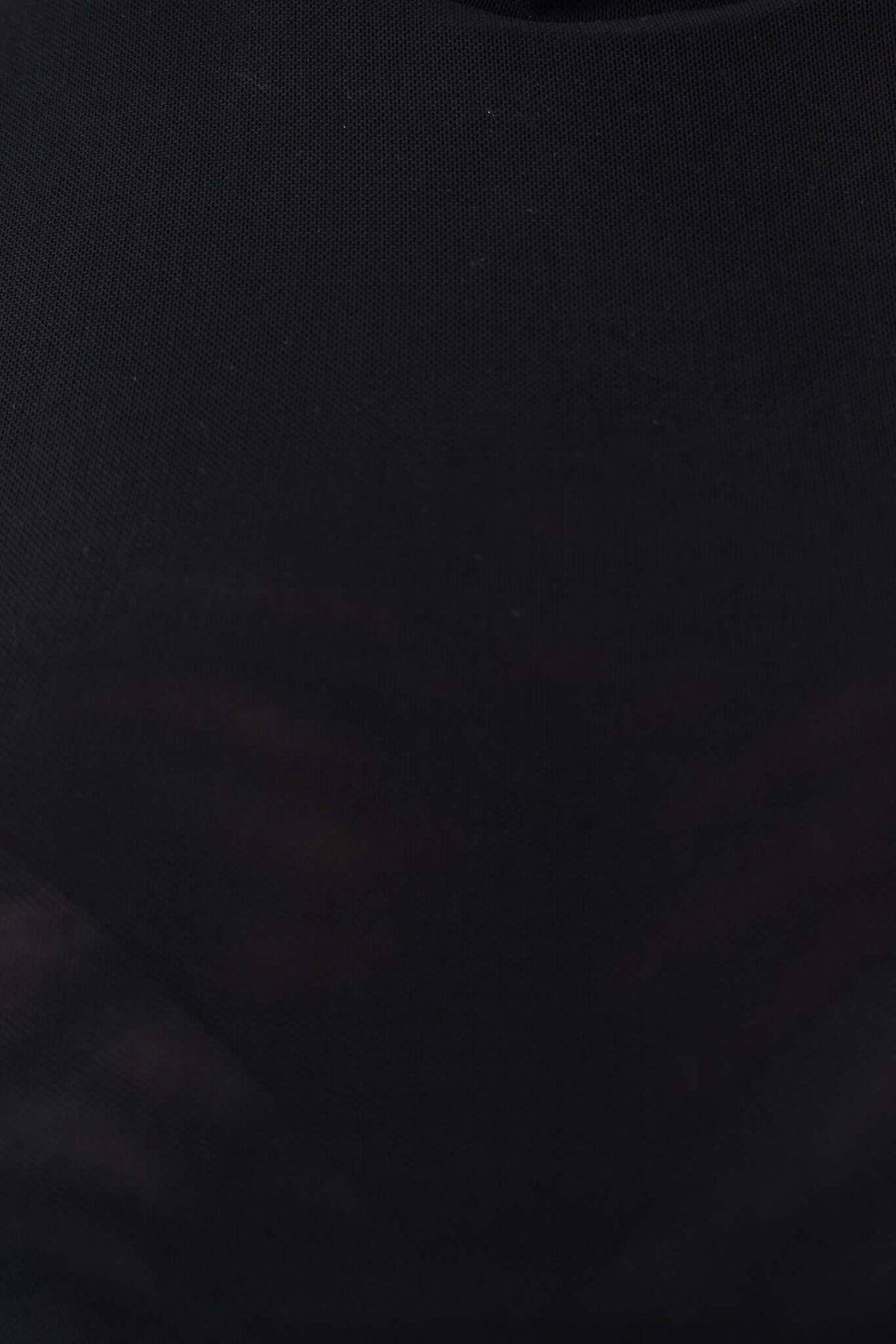 Close-up of a black mesh top with high neckline, showcasing button detail and lined material.
