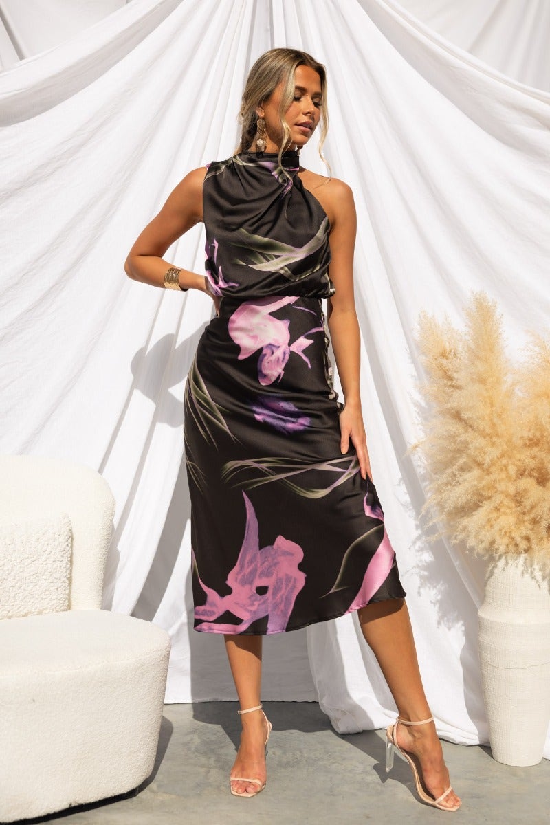 Irisse midi dress featuring a floral print, high neckline, and elegant silhouette in a stylish setting.