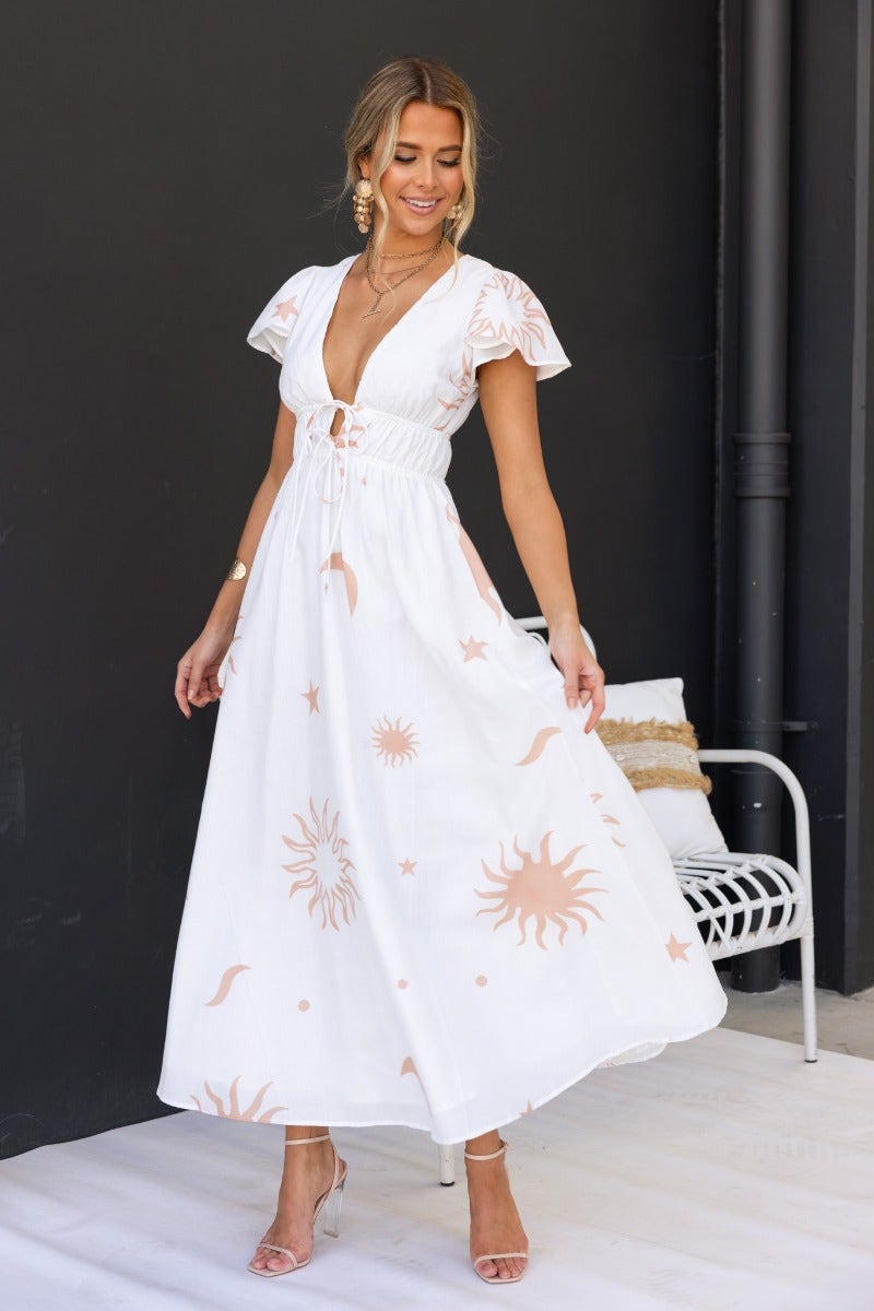 Model in a Milene Maxi Dress featuring V-neckline, tie detail, and sun print, perfect for summer outings.