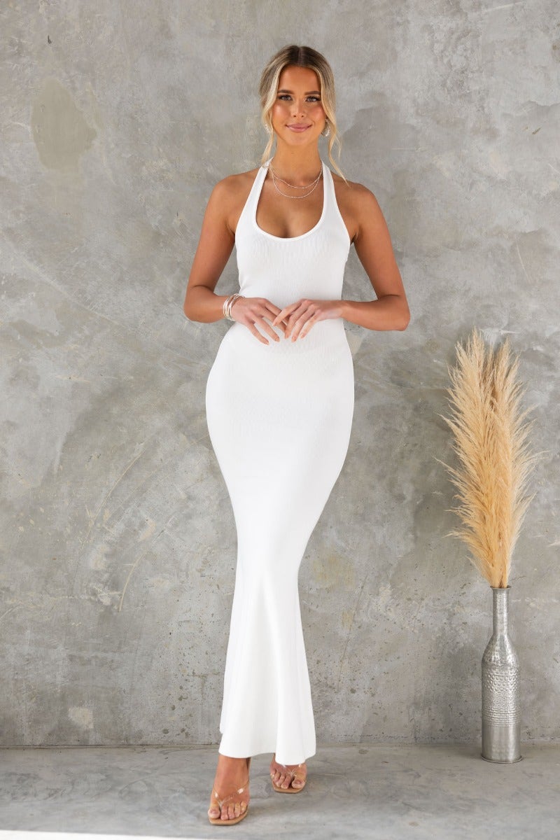 Model wearing a white ribbed halter maxi dress, showcasing a fitted silhouette against a neutral background.