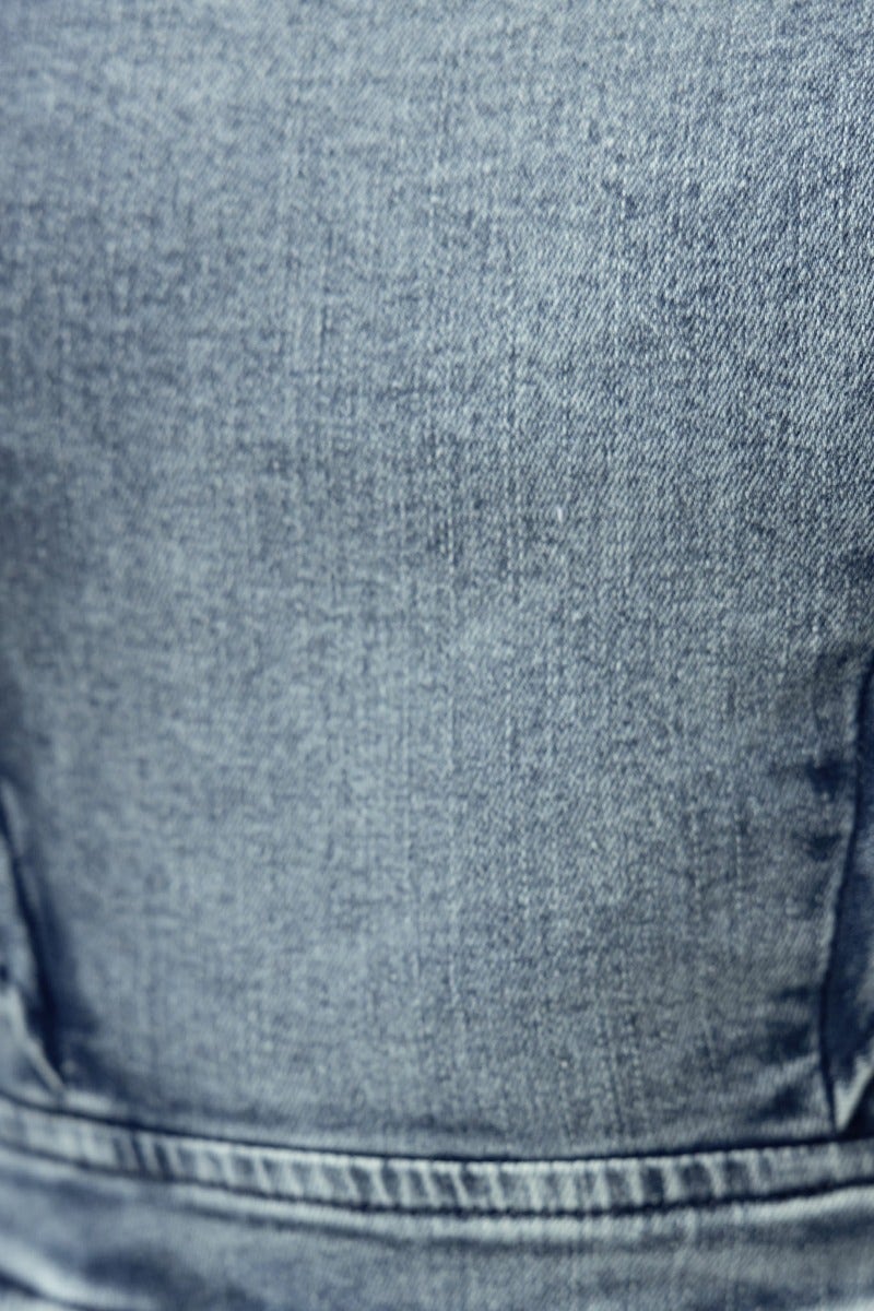 Close-up of soft denim fabric, showcasing the texture and color variations of a natty denim playsuit.