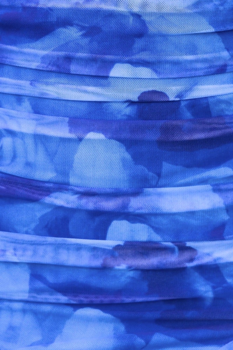 Close-up of blue fabric with ruching detail, showcasing the texture and color variations of the Carina Dress.