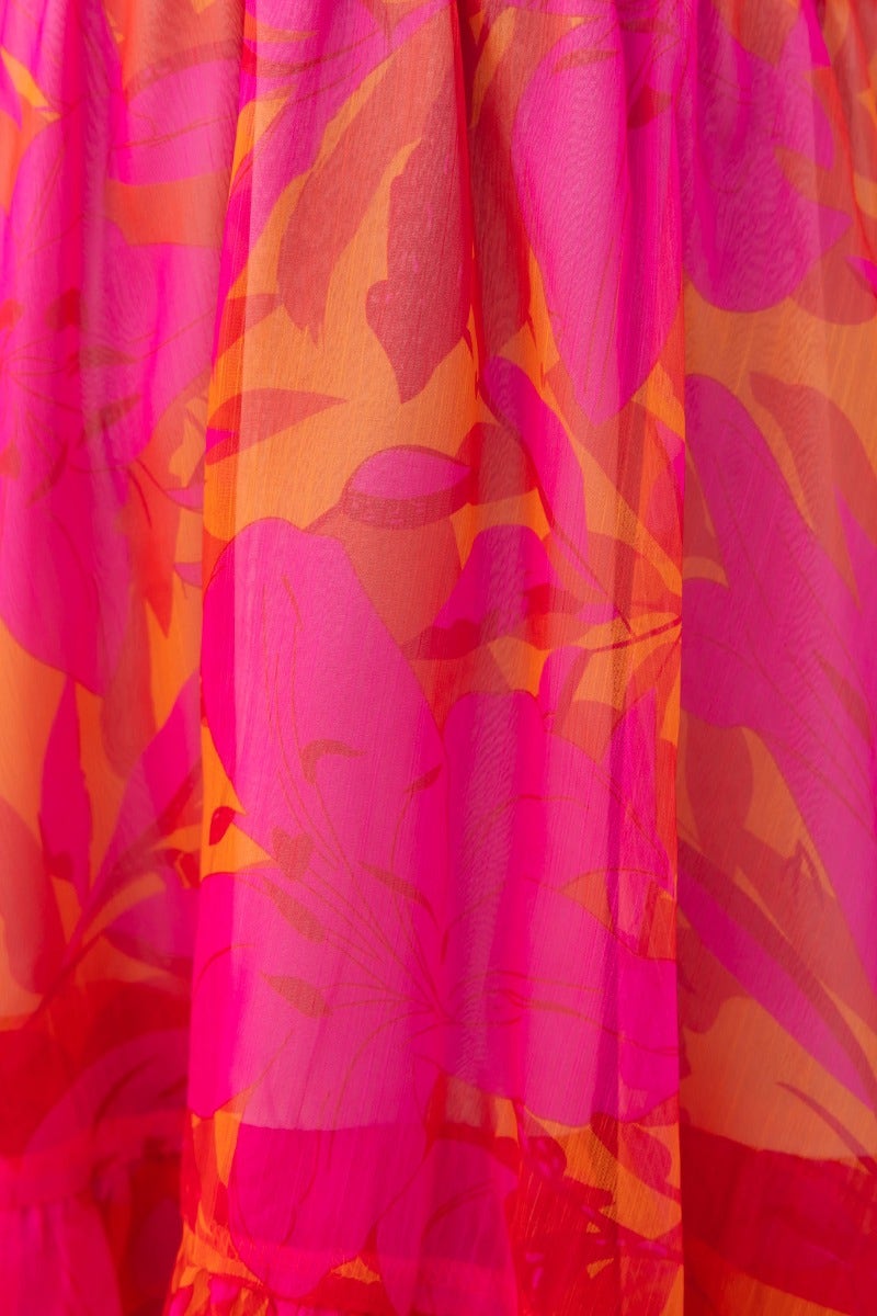 Bright floral print fabric in shades of pink and orange, showcasing a vibrant, soft texture for a stylish dress.