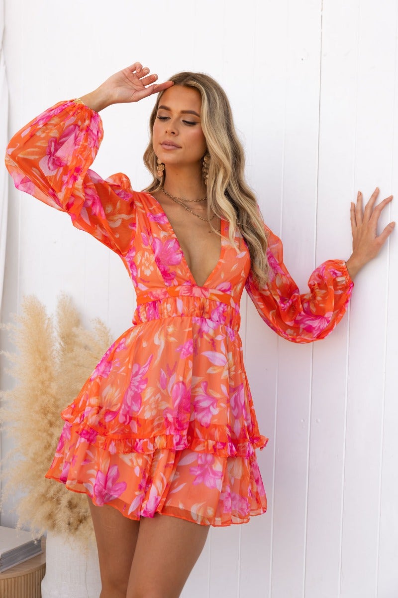 Floral print vanity dress with V-neckline and long sleeves, styled in vibrant pink and orange hues.