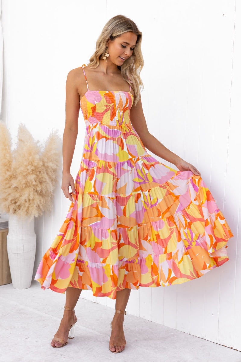 Model wearing multi-colour Island Cruise Midi Dress with adjustable straps and elastic bodice, featuring floral patterns.